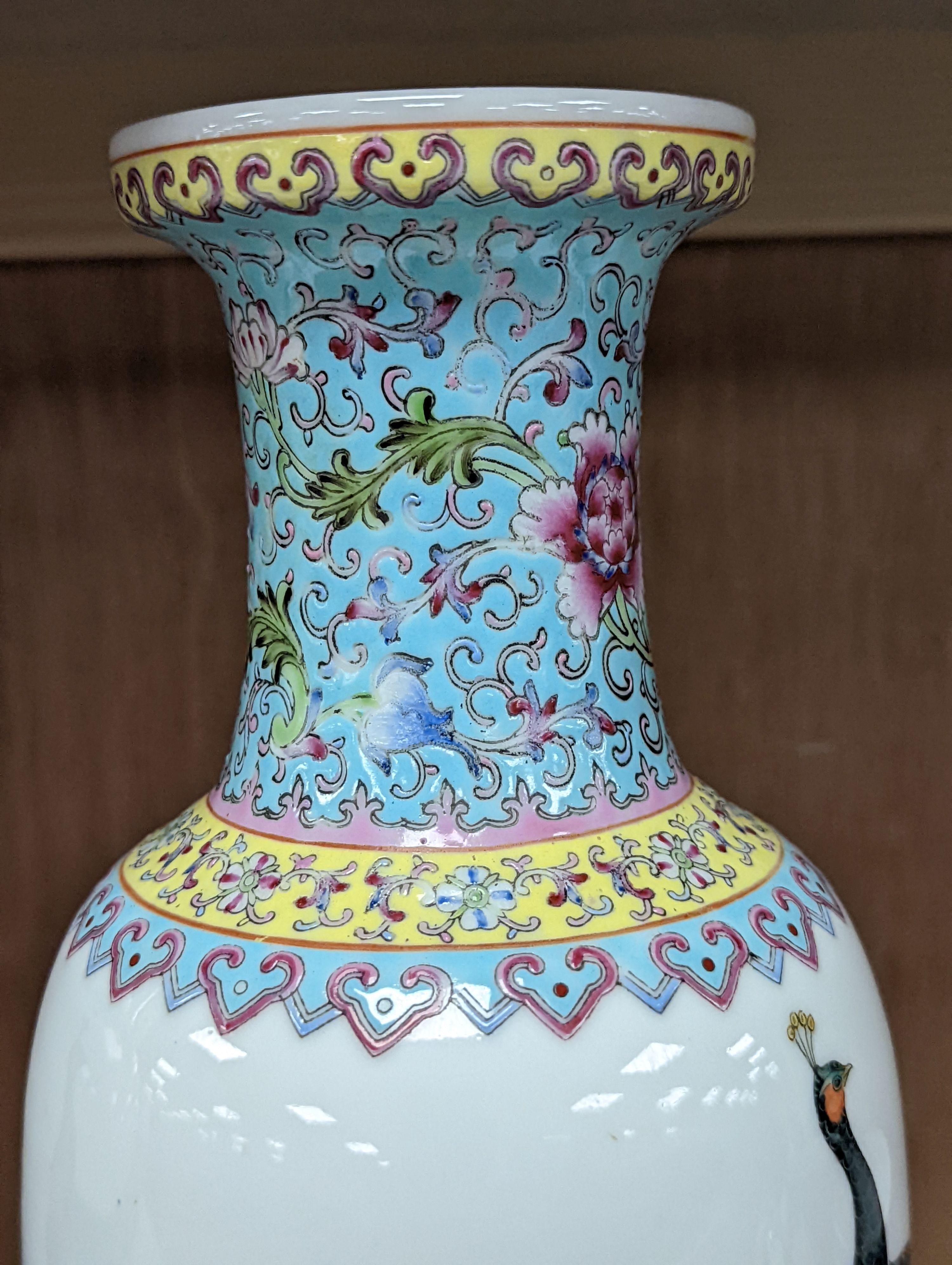 A pair of Chinese famille rose vases decorated with peacocks, 31cm